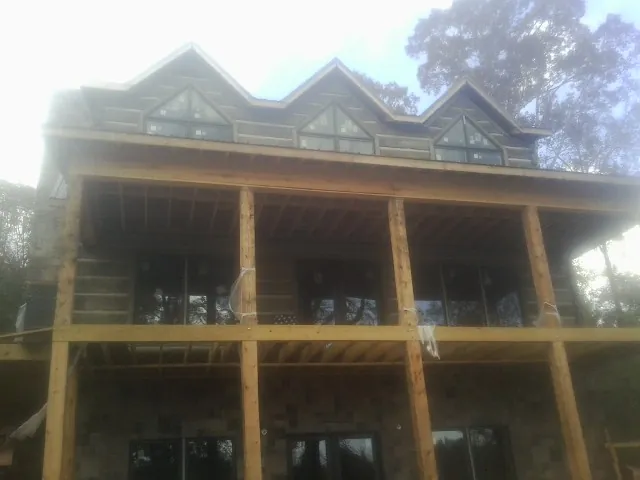 Dormers and porch framing on a large log home under construction — Roof Coating work by our crew in Elko