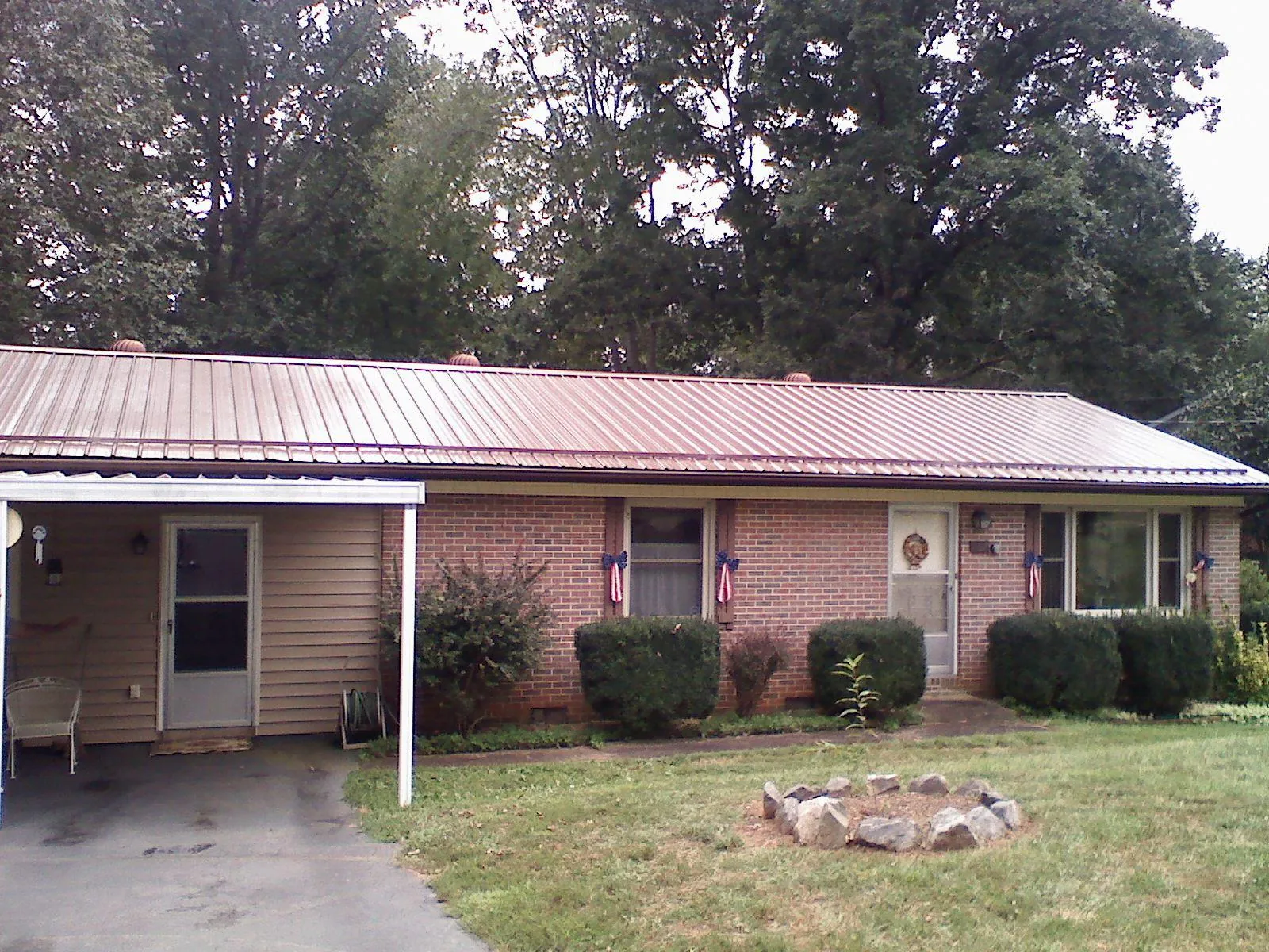 Bronze metal roof and carport on a brick ranch home — Roof Repair work by our crew in Elko